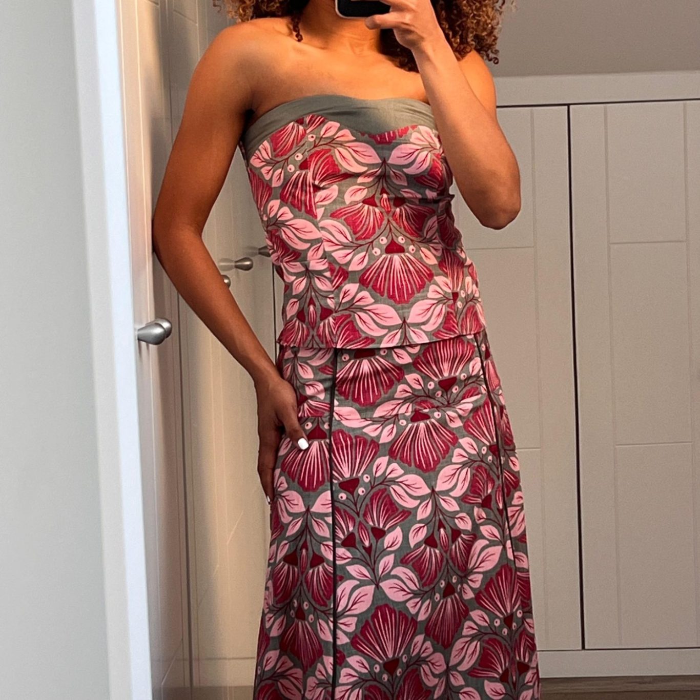 Mujer sonriendo, vestida con un vestido largo de estampado marrón y negro.