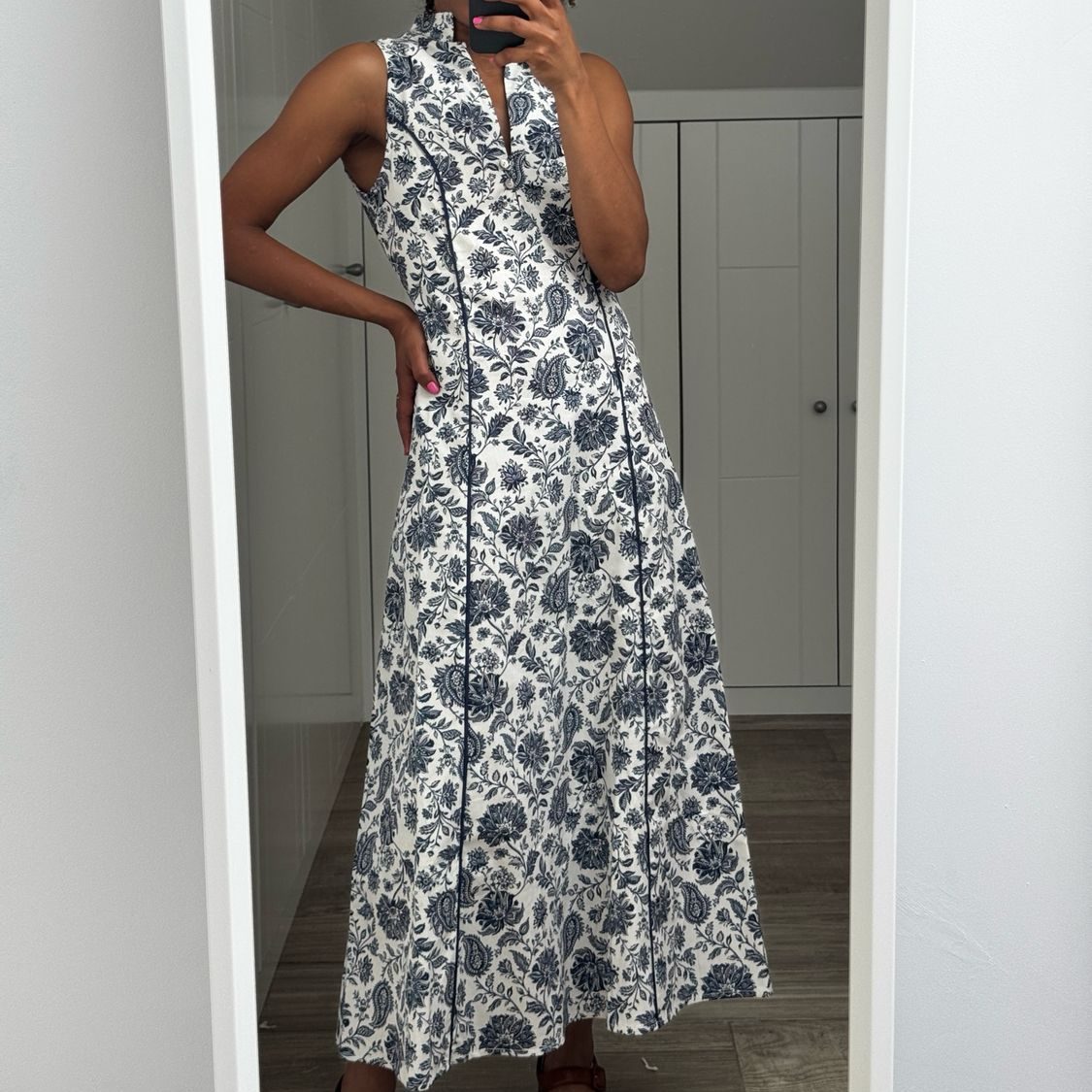 VESTIDOS Mujer sonriendo, vestida con un vestido largo de estampado marrón y negro.